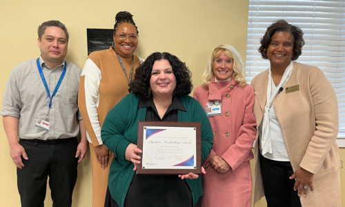  Lisa Pagano (center) holds a certificate for CMS' recognition as a Promising District.